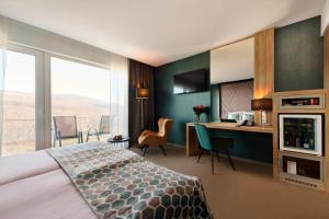 玛特阿哈泽Hotel Ózon & Luxury Villas的配有一张床和一张书桌的酒店客房