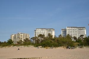 济夫努夫M&M Apartament Dziwnówek (z widokiem na morze)的海滩上有两个高大的建筑