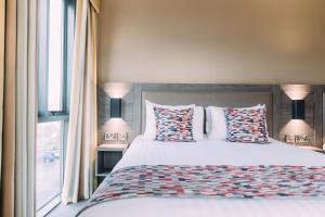 阿马经典英国阿尔马城市酒店的卧室配有带枕头的床铺和窗户。