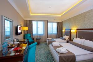 伊斯坦布尔商业中心酒店的酒店客房,设有两张床和一张沙发