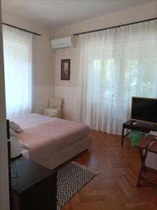 拉布Villas Arbia - Rio by the Beach的一间卧室配有一张床、一张书桌和一个窗户。