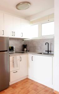 梅罗那瑞斯Apartamento Maypa 2 Salitre的厨房配有白色橱柜和不锈钢冰箱