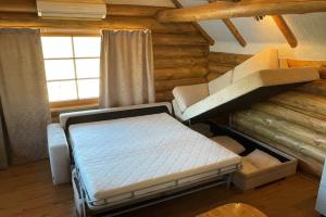KoloreinoKütioru saunamajad的小木屋内一间卧室,配有一张床