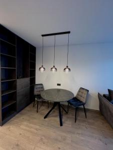 维尔纽斯J.Kairiūkščio apartamentai的一间设有玻璃桌和两把椅子的用餐室