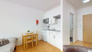 伦敦Superb Studio Apartment的厨房以及带桌子和沙发的用餐室。