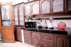 新德里Divine India Service Apartment,2Bhk, D-198,SAKET的厨房配有木制橱柜和台面