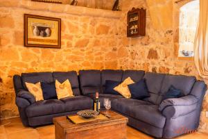 MunxarMatli Farmhouse, your stunning Gozo getaway.的客厅配有蓝色的沙发和桌子