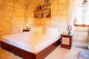 MunxarMatli Farmhouse, your stunning Gozo getaway.的卧室配有一张石墙床