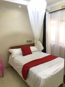 KakamegaLudali homes的一间卧室配有一张带红色毯子的大床
