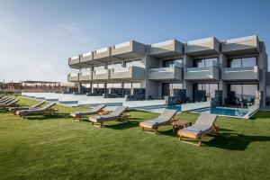 古瓦伊Crete Resort Sea Side Suites "Adults Only" by Checkin的一座带一排椅子和游泳池的建筑