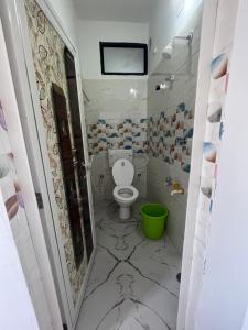 西里古里Marigold Hotel的一间带卫生间和绿色桶的浴室