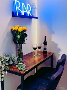 温彻斯特Winchester Retreat的一张木桌,放上两杯葡萄酒和鲜花