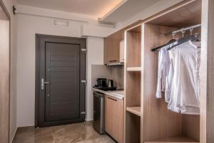 古瓦伊Crete Resort Sea Side Suites "Adults Only" by Checkin的一间厨房,内设木制橱柜和一扇门
