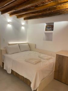 KóstosCozy apartment Kostos的白色房间的一个床位,上面有两条毛巾