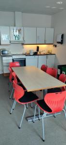 斯塔万格苏伯格福克胡斯克旅馆的厨房配有木桌和红色椅子