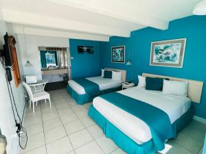 大松礁岛Big Pine Key Motel的蓝色的客房配有两张床和一张桌子