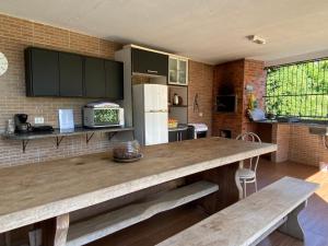 伊瓜苏Grey House的厨房配有带2张长凳的大木桌