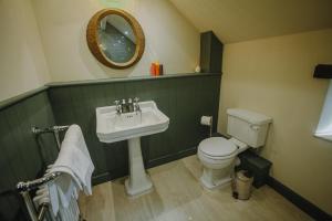 泰德斯韦尔Vicarage Farm Cottages的一间带水槽、卫生间和镜子的浴室