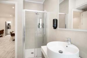塞维利亚Apartamentos Recaredo 7的带淋浴和盥洗盆的白色浴室