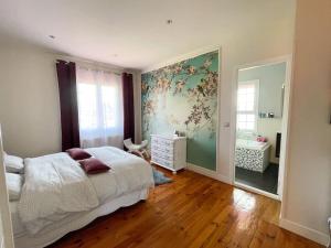 巴约讷Belle maison familiale Basque的一间卧室配有一张床、梳妆台和镜子