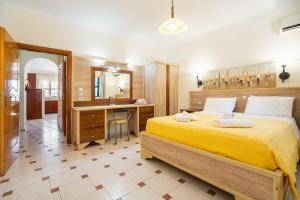 里瓦的亚Livadia Beach Suite的一间卧室配有一张黄色的大床和一张书桌
