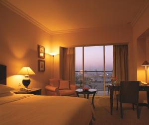开罗尼罗河大厦酒店的配有一张床、一张书桌和一扇窗户的酒店客房