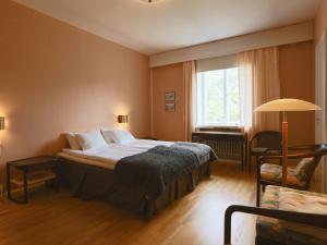 科沃拉Myllykosken Kerho Oy的卧室配有床、椅子和窗户。