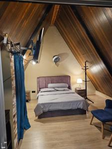 金马仑高原Orkid Chalet的阁楼上的卧室配有一张大床