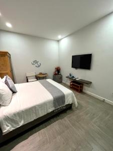 潘切Homestay Song Ngọc Phan Thiết的一间卧室配有一张床和一台平面电视