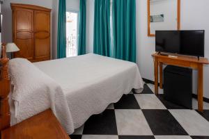 科尼尔-德拉弗龙特拉绿洲酒店的一间卧室配有一张床和一台平面电视