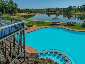 白河Blue Zone Leisure at Pine Lake Inn Resort的一座大型游泳池,后面是湖泊