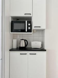 波里Aava's apt. FREE Parking的厨房配有白色橱柜和微波炉