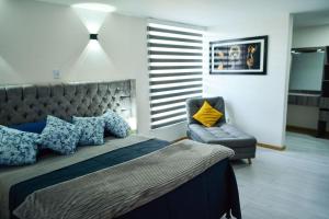 马尼萨莱斯Apartamentos cómodos en Milan zona G的一间卧室配有一张大床和一把椅子