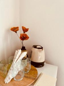 乌马格San Marco Luxury Rooms Umag的桌子、玻璃杯、茶壶和鲜花