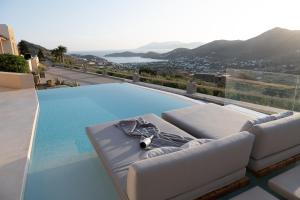 伊奥斯乔拉Youtopia Ios Villas的一个带沙发和桌子的游泳池