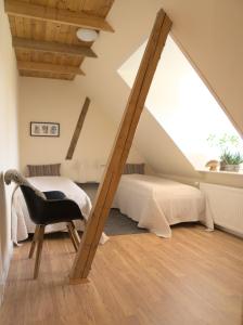 HårlevAkaciegaarden Bed & Breakfast的阁楼卧室配有床和椅子