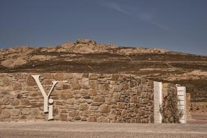 埃利亚海滩Yi Hotel Mykonos的石墙,上面写着大字母k