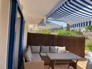 弗拉门卡海滩Casa Monet - La Calma - 4 pools- Big terrace - Orihuela Costa的阳台的天井配有沙发和桌子
