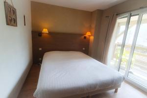 勒波诺Hotel Alicia Auray Le Bono的卧室配有白色的床和窗户。