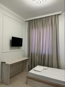 阿特劳Hotel Bereke的卧室配有一张床,墙上配有电视