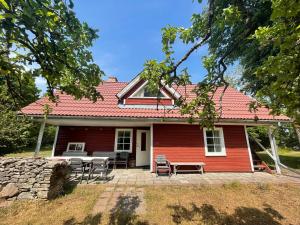 VanamõisaAaviku Holiday Houses的前面有一张桌子和椅子的红色房子
