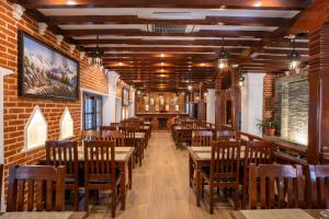 加德满都Airport Himalaya Boutique Hotel的餐厅设有木桌和椅子,拥有砖墙