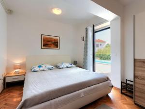 波雷奇Holiday Home Suncana by Interhome的一间卧室设有一张床和一个滑动玻璃门