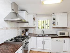 卡隆赫Holiday Home Origami by Interhome的厨房配有白色橱柜和炉灶烤箱。