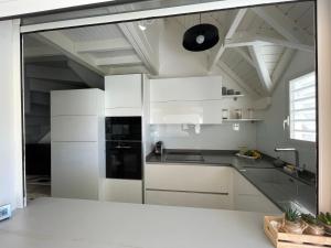 圣弗朗索瓦Pitaya - T3 cosy en duplex avec cuve的厨房配有白色橱柜和黑色冰箱。