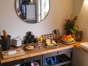 圣特罗佩Lou Riou Village Vacances的一张桌子,上面有面包和水果,还有镜子
