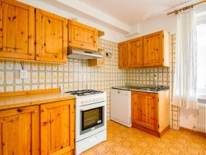 莫埃纳Apartment Mantina-1 by Interhome的厨房配有木制橱柜和白色炉灶烤箱。