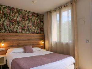 圣特罗佩Lou Riou Village Vacances的一间卧室设有一张大床和一个窗户。