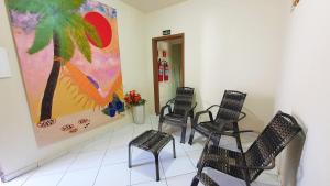 康塞桑达巴拉Pousada Beth Shalom的一间设有椅子和墙上一幅画的等候室