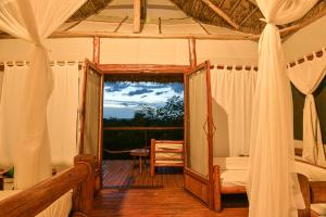 卡塞斯Kazinga Wilderness Safari Camp的一间设有床铺和镜子的甲板客房